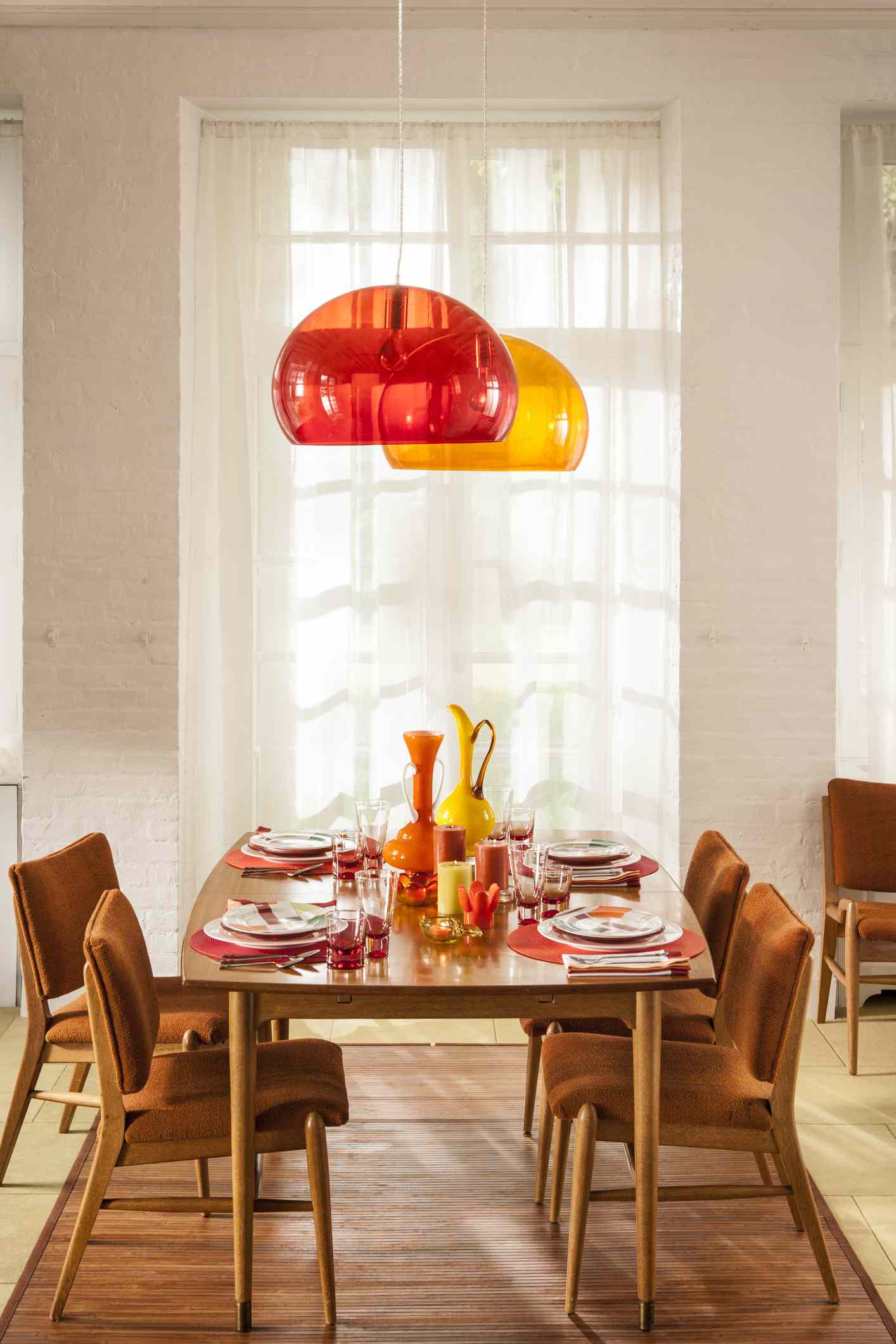 Table à manger et chaises avec suspensions rouges et jaunes au-dessus