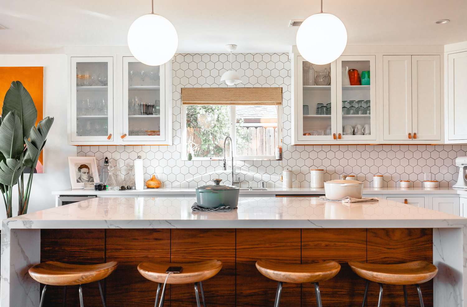 Cuisine à la décoration lumineuse avec stores romains en bambou couvrant la fenêtre au-dessus de l'évier