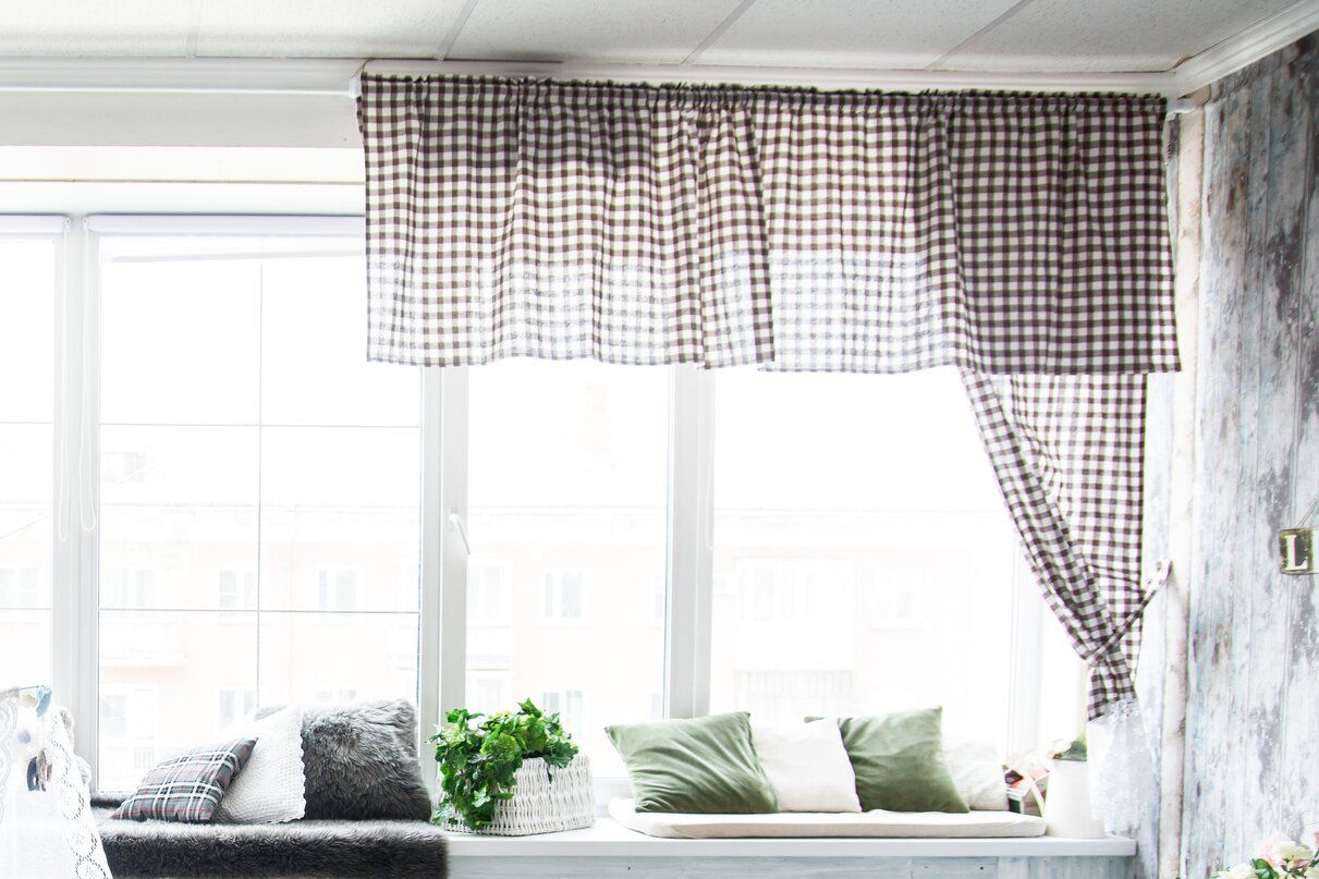 Rideau cantonnière à carreaux noir et blanc devant la fenêtre lumineuse