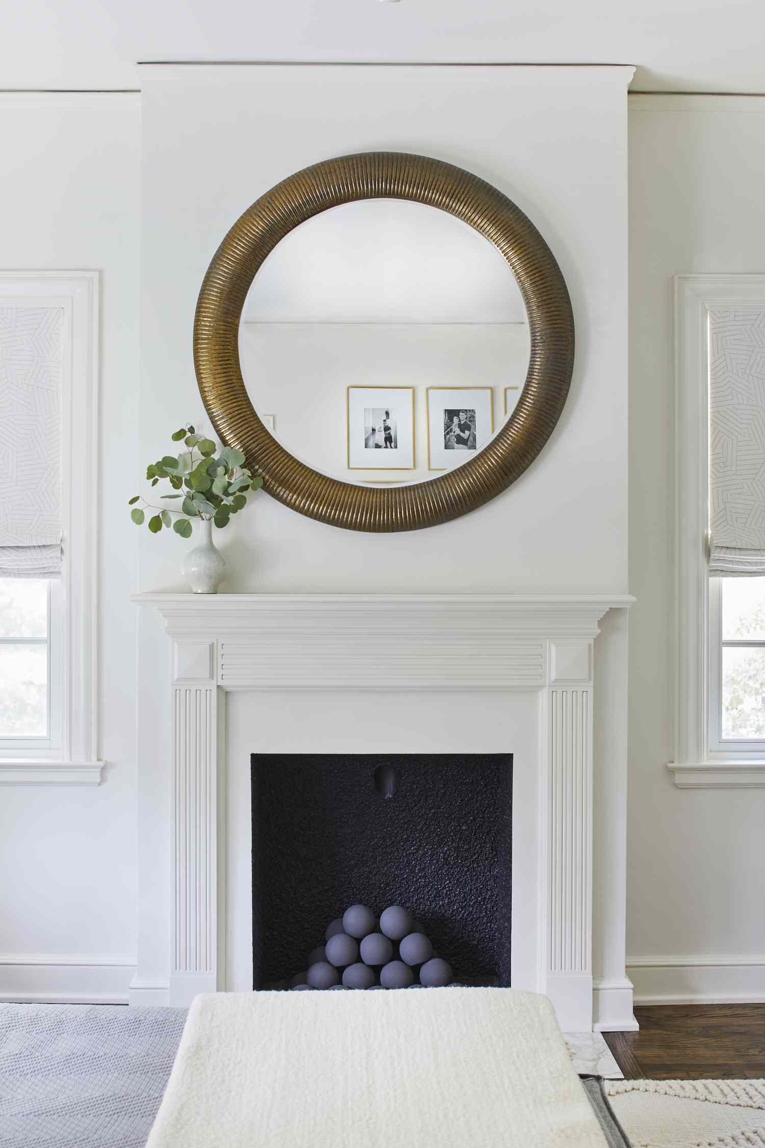 Un foyer au gaz blanc avec un grand miroir rond