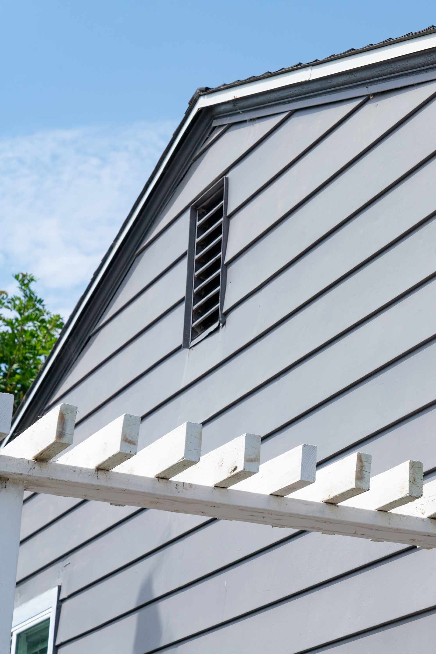 Revêtement de maison en vinyle gris sur le côté de la maison avec gros plan de garniture blanche