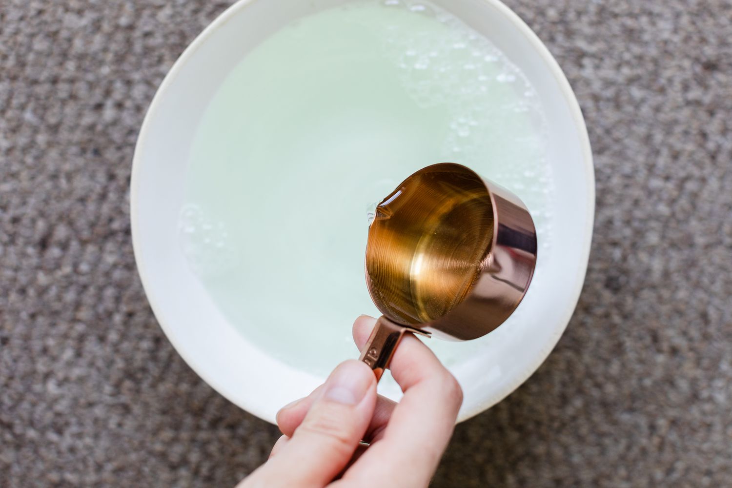 Bol blanc d'eau mélangée à du vinaigre blanc distillé et du liquide vaisselle pour la solution de nettoyage du fromage à la crème