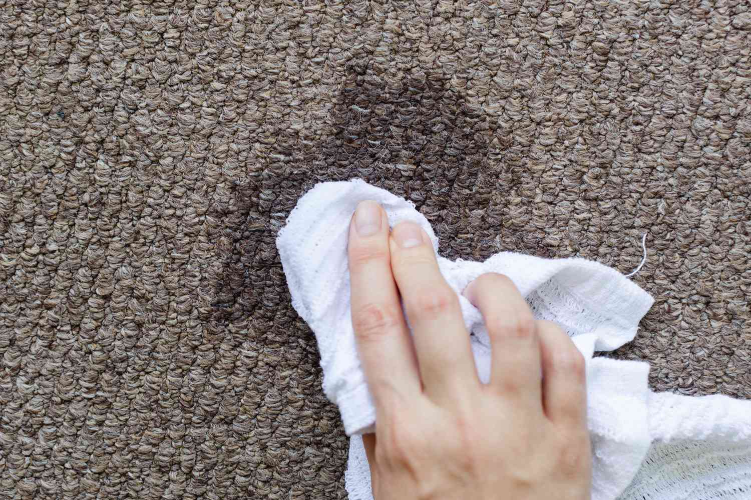 Tapis rincé avec un chiffon propre et humide sur la tache de fromage à la crème