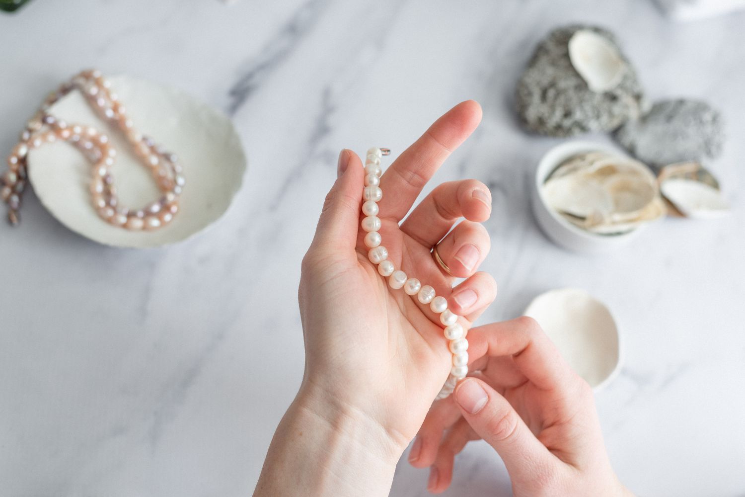 personne inspectant les bijoux en perles