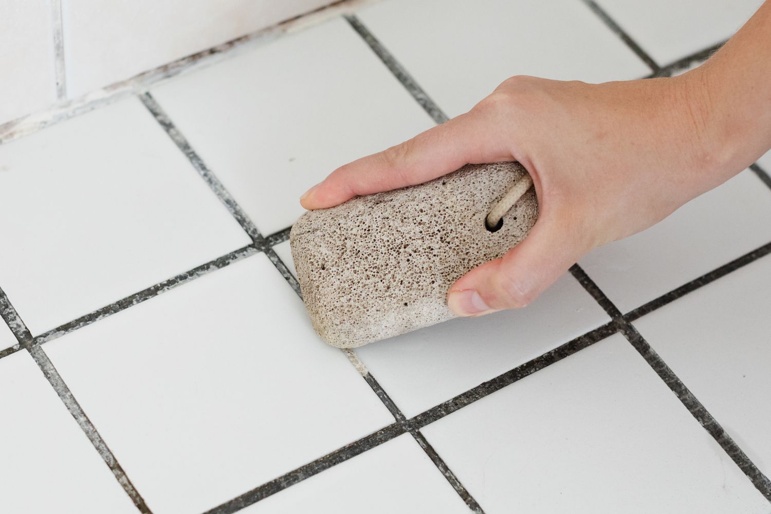 Utiliser une pierre ponce pour nettoyer le sol de la salle de bain