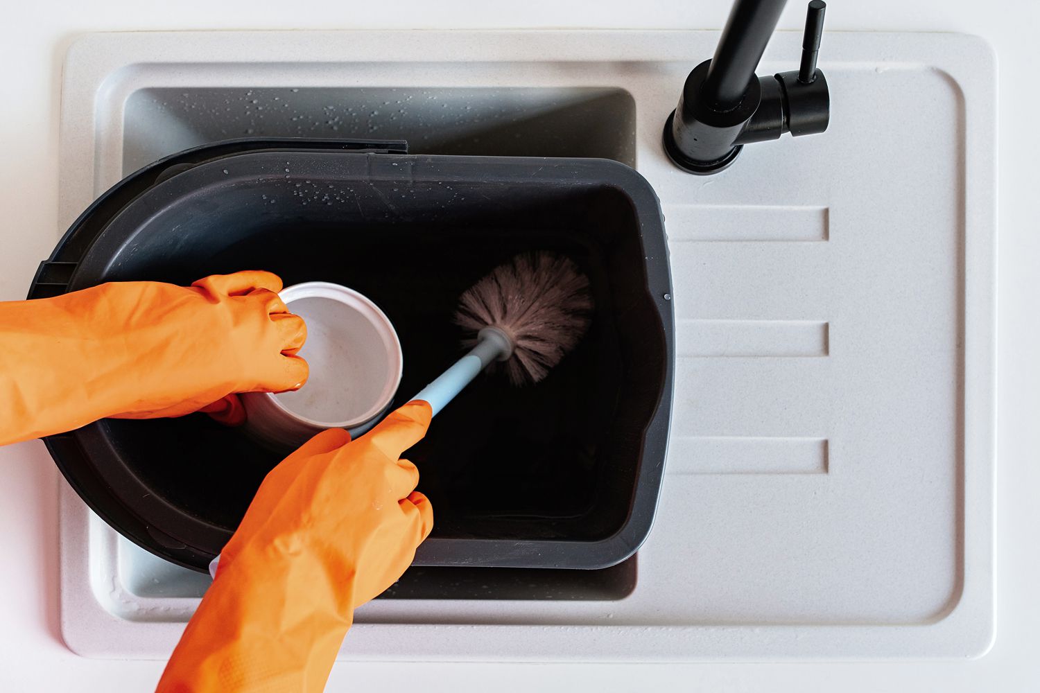 Immerger la brosse de toilette et le support dans un seau de solution d'eau de Javel