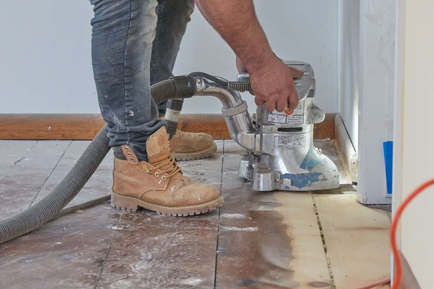 Ponceuse passant sur plancher de bois franc à la main et cordon de cadre de porte