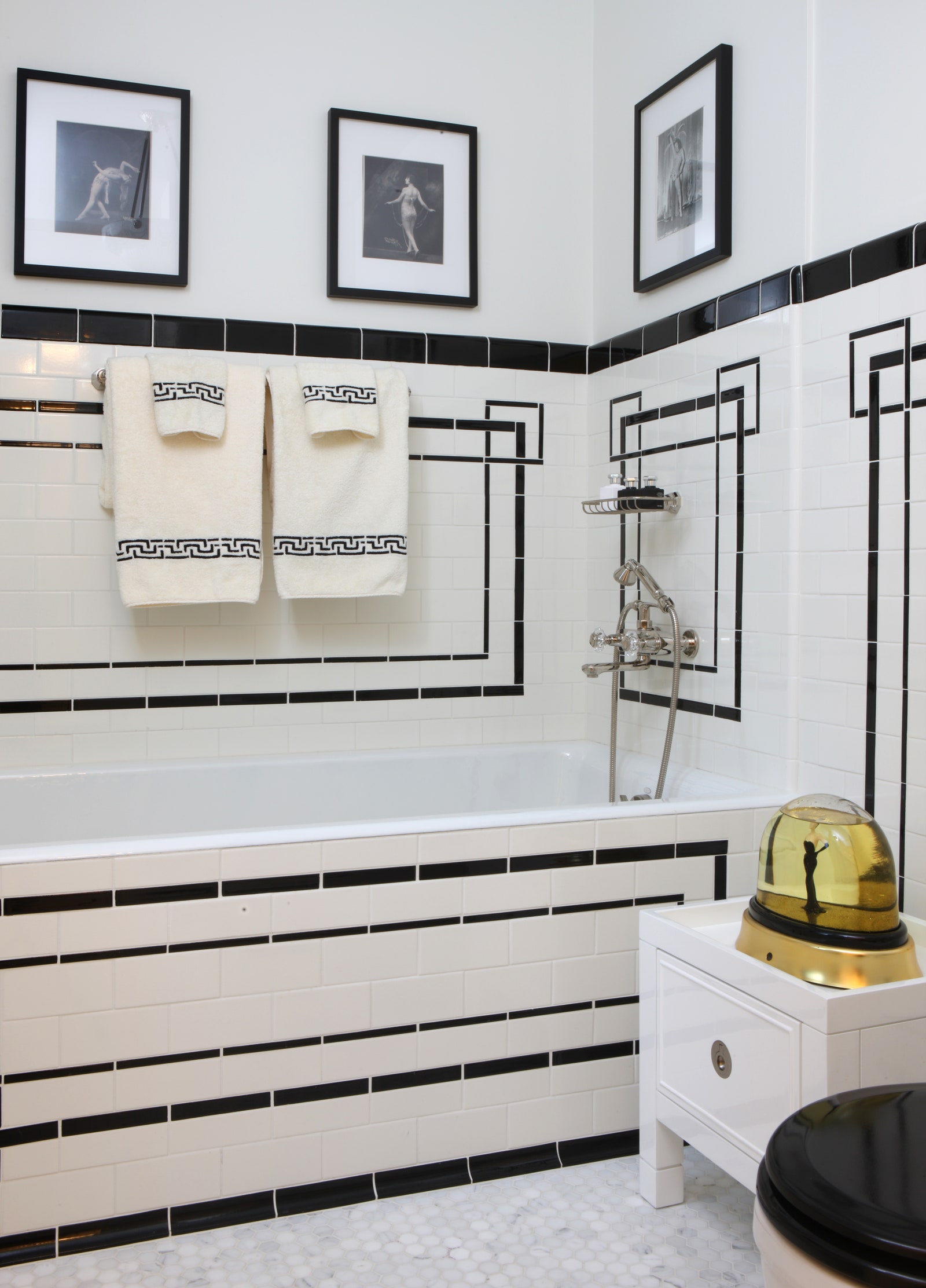 Carrelage de salle de bain blanc avec accents noirs baignoire toilette avec siège noir