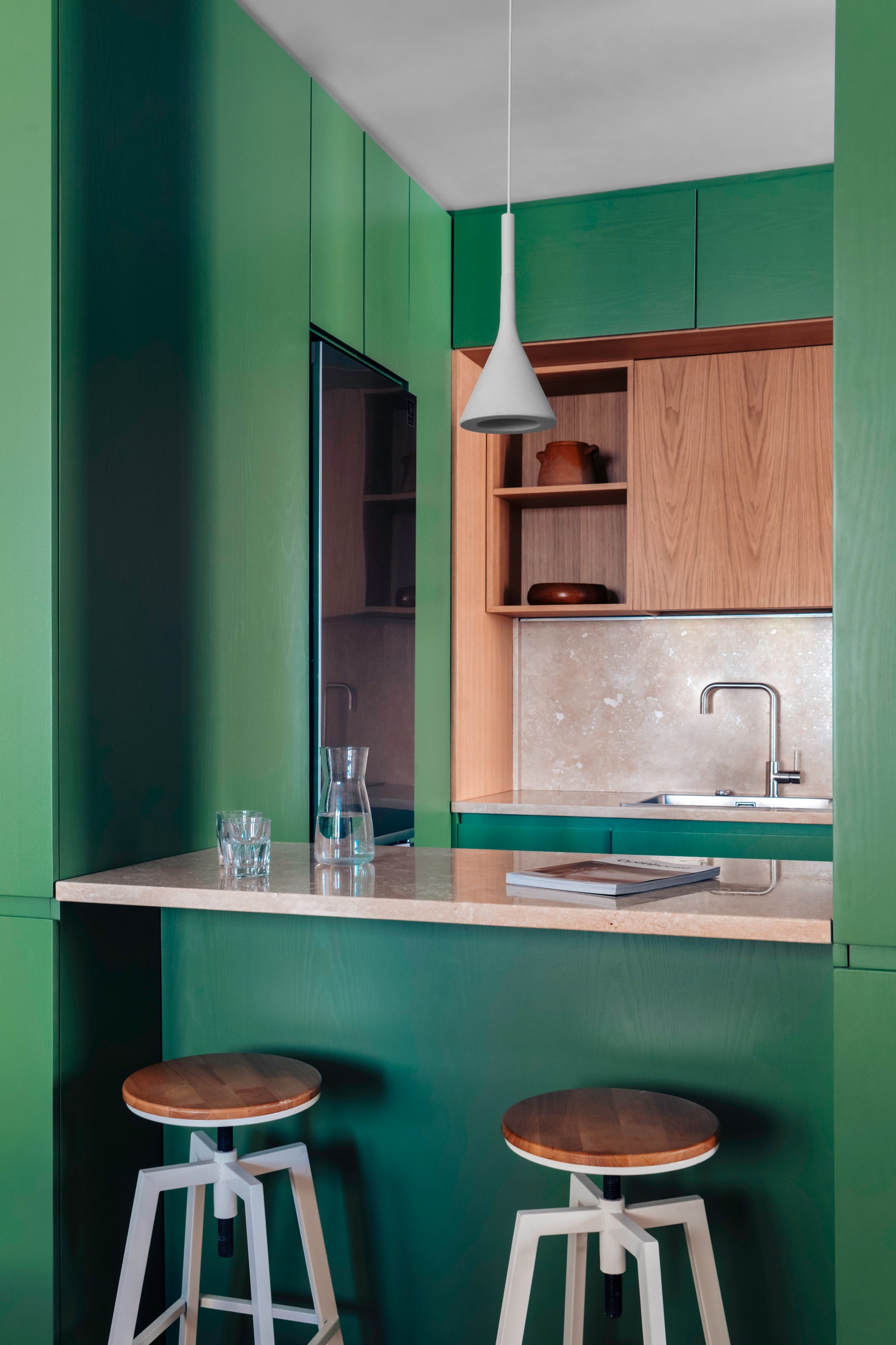 Une cuisine verte dans un appartement à Rome avec des armoires vertes et des armoires en bois