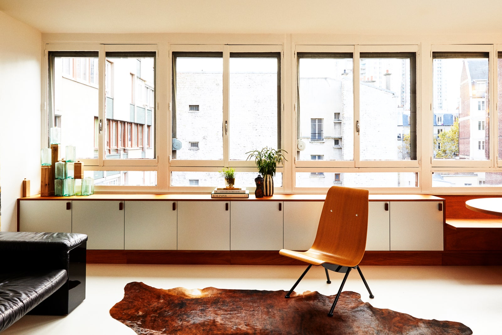 L'image peut contenir des meubles de salle à l'intérieur de la table, une chaise, un sol, un tapis de sol en bois et un salon.