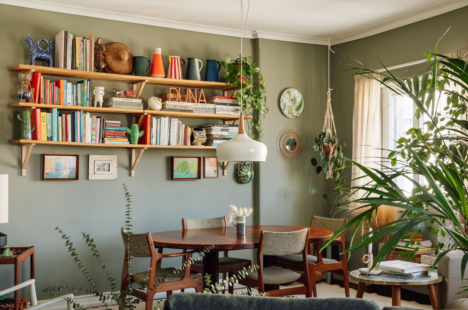 L'image peut contenir des meubles chaise intérieur design d'intérieur salon étagère table bibliothèque et plante